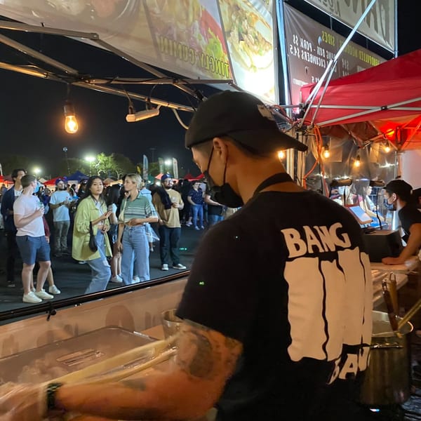 A Bang Bang Noodles chef prepares food at a bustling night market stall.